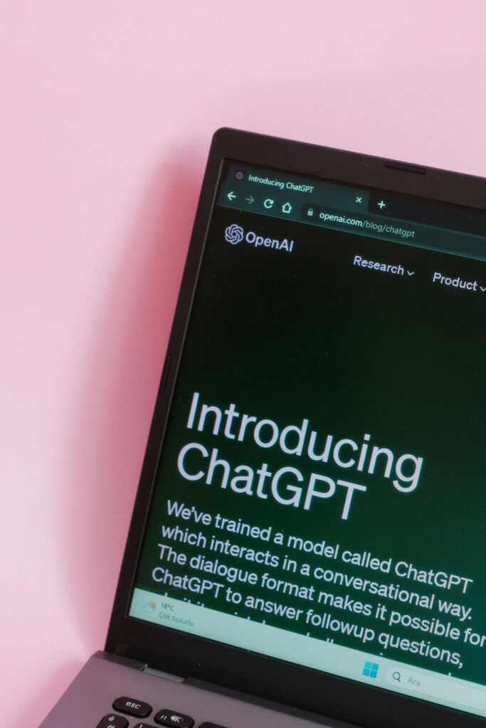 pexels-photo-16245253-16245253 Close-up of a laptop with ChatGPT introduction on screen against a pink background.