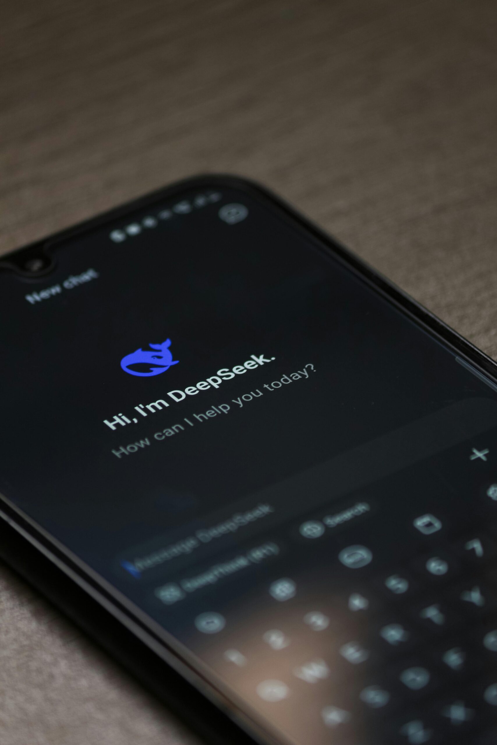Close-up of smartphone screen showing AI chatbot interface on dark mode with text input.